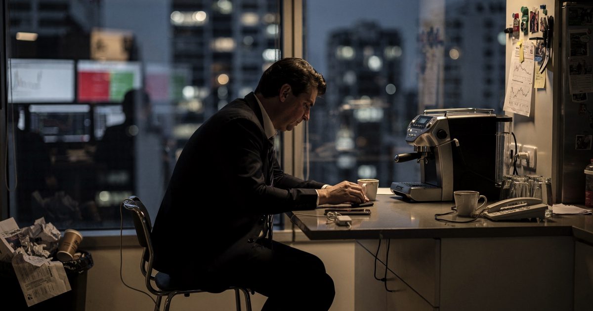 Medium shot inside a hedge fund office kitchen in São Paulo late at night, a trader in a loosened tie seen only as a dark silhouette against a floor-to-ceiling.
